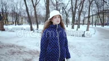 冬天迷人的卷发女孩。 <strong>年轻</strong>漂亮的女人穿着蓝色夹克，戴着白色帽子，背景是白雪。 这<strong>就是</strong>